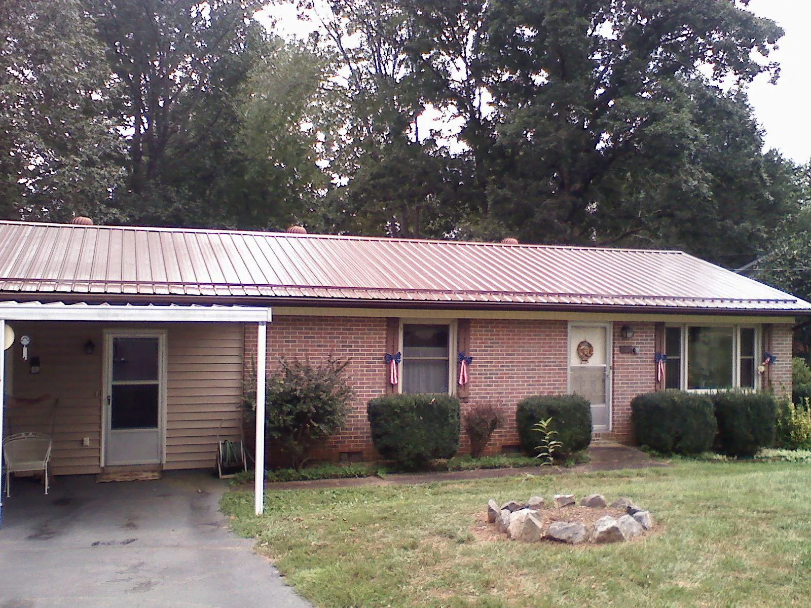 Bronze metal roof and carport on a brick ranch home — Roof Repair work by our crew in Andover